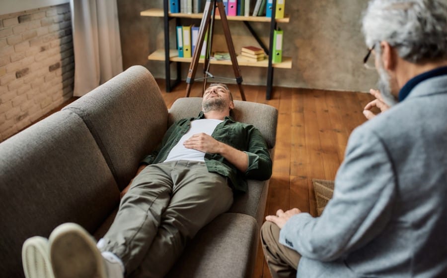stock-photo-calm-young-caucasian-man-lying-on-couch-with-closed-eyes-during-psychotherapy-session-in-office-1926445154